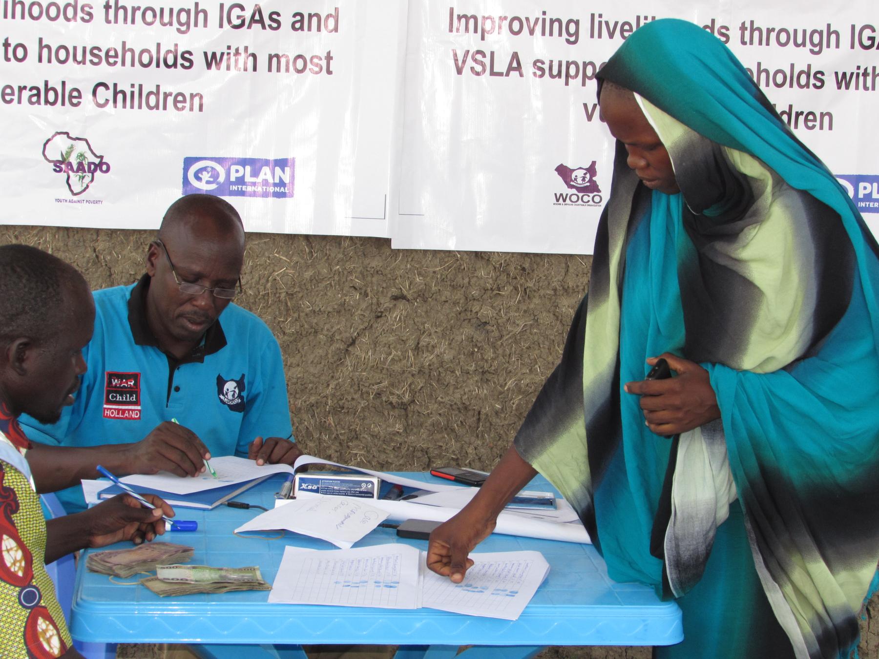 A beneficiary is signing payment sheet for IGA support- Photo courtesy by WOCO
